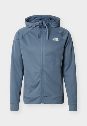 Niebieska bluza z pełnym zamkiem, regulowanym kapturkiem na sznurki, długimi rękawami, bocznymi kieszeniami oraz białym logo The North Face na lewej piersi.