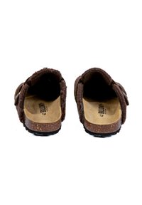 Chaussures slip-on en feutre marron avec semelle intermédiaire en liège, semelle extérieure en caoutchouc, deux sangles et logo imprimé sur la semelle intérieure. Texture douce avec bords arrondis.