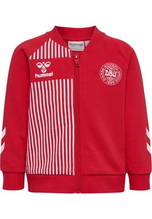 Rød sportstrøje med lynlås og hvide lodrette striber på venstre front, Hummel-logo og Dansk Boldspil-Union-emblem på brystet.