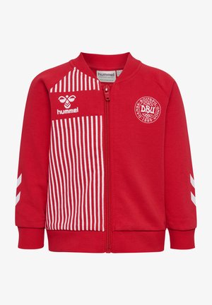 Rød sportstrøje med lynlås og hvide lodrette striber på venstre front, Hummel-logo og Dansk Boldspil-Union-emblem på brystet.