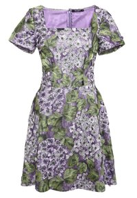 Blommig klänning med lila bas, gröna blad och vita blommor. Fyrkantig halsringning, korta ärmar och en figurnära silhuett.
