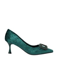 Zapato de charol en color verde azulado con punta afilada y una hebilla decorativa de piedras brillantes en el empeine. Presenta un tacón delgado y transparente.