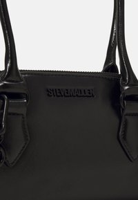 Sac à main synthétique noir avec une finition brillante, doté de deux poignées et du logo "STEVE MADDEN" gaufré à l'avant. Fermeture éclair sur le dessus.
