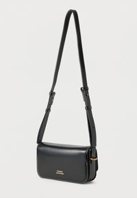 Μαύρη δερμάτινη τσάντα χιαστί με χρυσό λογότυπο, ρυθμιζόμενο λουρί και λευκά ράμματα. Διαθέτει ορθογώνιο σχήμα και λεία υφή.