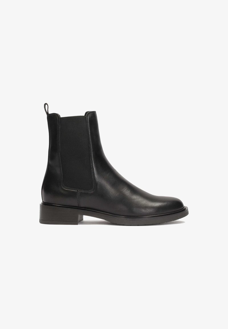 Bottine Chelsea en cuir noir avec panneaux latéraux élastiques, talon bloc bas et languette à l'arrière.