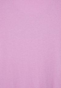 Tissu rose pâle avec une texture lisse. Le matériau semble léger et uniforme, sans motifs ni accessoires visibles.