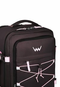 Černý látkový batoh s růžovými detaily, vybavený přihrádkou na zip, předním designem s pružným lanem a horním madlem pro nošení.