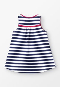 Pruhované bezramínkové šaty v navy a bílé, s červeným akcentem na výstřihu a skládáním na zádech, vyrobené z lehkého materiálu.