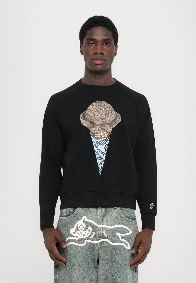 Zwarte sweatshirt met een grote afbeeldingen van een ijsje in beige en blauw. Kenmerkt zich door een ronde hals en geribbelde manchetten. Gedetailleerd met opvallende accenten op de broek.