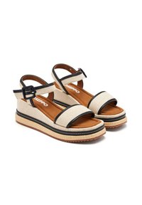 Sandali platform in tela beige con dettagli neri, cinturino alla caviglia regolabile e suola testurizzata. Presentano due ampie cinghie sopra il piede.