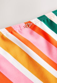 Multifarvet stribet stof med pink, orange, gul, hvid og grønne nuancer. Inkluderer gulddetalje øverst.