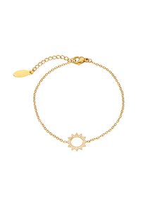 Finom arany lánc karkötő napforma charm-mal, amely kis átlátszó drágaköveket tartalmaz, és rántós kapoccsal, amely állítható lánccal rendelkezik.