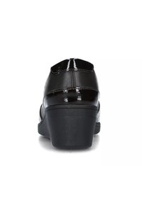 Scarpa in vernice nera con punta tonda, tacco di altezza media e superficie liscia e brillante. Presenta un design semplice con pochi accessori.