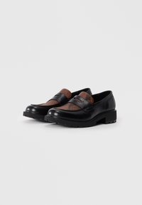 Sorte skinnloafers med et brunt teksturert vamp, med firkantet tå, solid såle og dekorativ søm på overdelen.