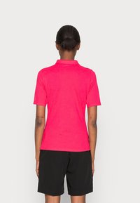 Fialový polo tričko s krátkými rukávy a límcem, s hladkou texturou. V kombinaci s černými šortkami, které mají jednoduchý a čistý design.