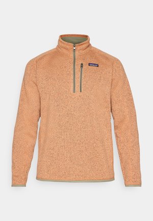Orange fleece pullover with a half-zip collar, textured fabric, and contrasting green accents along the zipper and hem. Patagonia logo on chest.