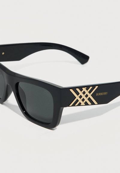 Μαύρα ορθογώνια γυαλιά ηλίου με σκούρους φακούς, διακοσμημένα με χρυσό λογότυπο Burberry και γεωμετρικό σχέδιο στους βραχίονες.