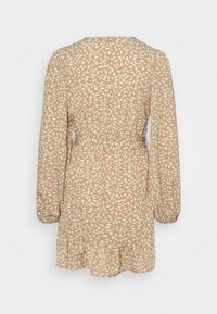 Vestido beige de manga larga con patrón floral blanco, cintura ceñida, puños elásticos y dobladillo con volantes, visto desde atrás.