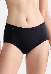 Slip nero in cotone con bordo in pizzo smerlato in vita, caratterizzato da una texture liscia e una vestibilità aderente, con etichetta del logo visibile sul lato.