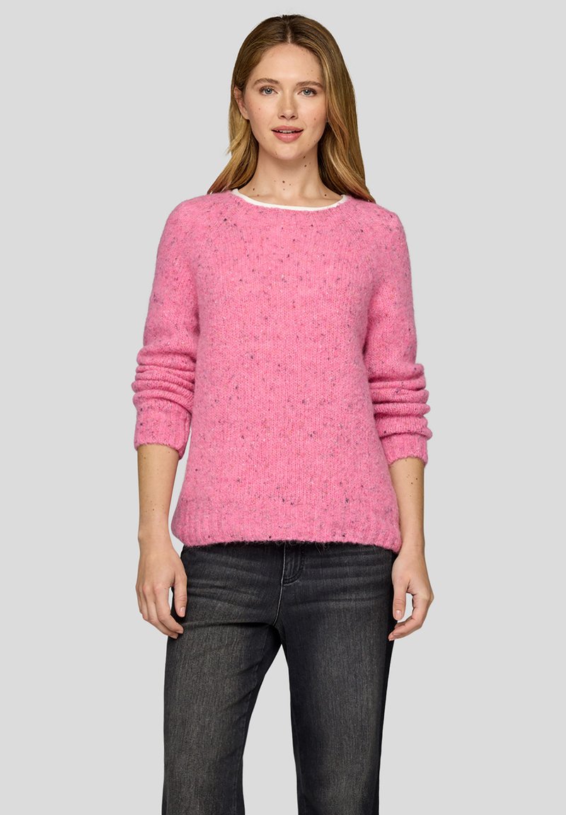 Rosa Wollmischpullover mit Rundhalsausschnitt, langen Ärmeln und gerippten Bündchen, mit gesprenkelter Textur und lockerem Schnitt. Kombiniert mit dunklen Jeans.