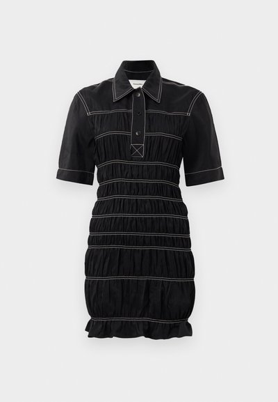 Rochie neagră cu mâneci scurte, guler cu nasturi și textură plisată. Prezintă cusături albe contrastante și o margine volan.