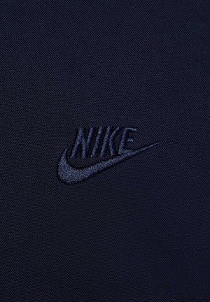 Navy fabric with a textured surface featuring an embroidered black Nike logo. Simple, clean design with no additional patterns or details.