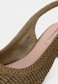 Hnědá tkaná nazouvací bota s texturovaným svrškem, hladkou vnitřní podšívkou a odolnou podrážkou. Obsahuje propracovaný tkaný design a pevný pásek.