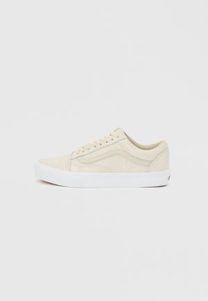 Beige lavt snøresko med tekstur, hvit såle og sidestrek, sett fra yttersiden på en nøytral bakgrunn.