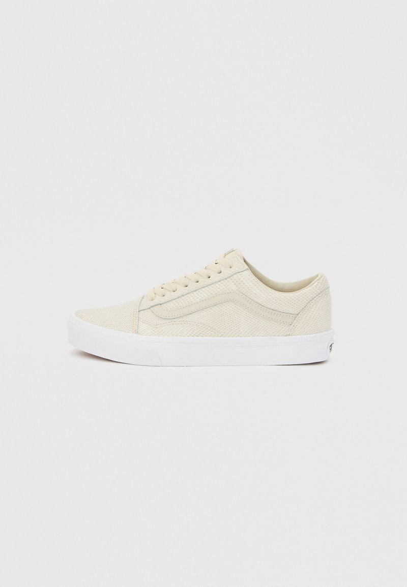 Χαμηλό μπεζ αθλητικό παπούτσι με υφή, λευκή σόλα και πλευρική ρίγα, εμφανίζεται από την εξωτερική πλευρά σε ουδέτερο φόντο.