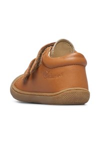 Scarpa in pelle marrone chiaro con forma arrotondata, dotata di una cinturino in velcro. Interno morbido e testurizzato e suola in gomma con grip testurizzato.