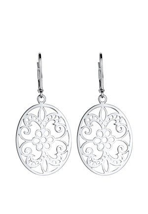Silver oval dangle earrings with floral and swirl cutout patterns hanging from lever-back clasps on white background.