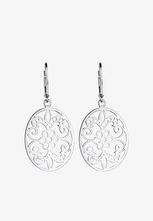 Boucles d’oreilles ovales pendantes en argent avec des motifs découpés floraux et en spirale suspendues à des fermoirs à levier sur fond blanc.