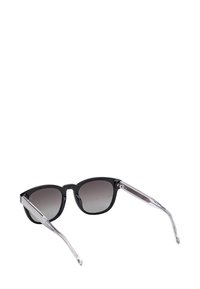 Czarne okulary przeciwsłoneczne z gradientowymi ciemnymi szkiełkami i przezroczystymi ramionkami na białym tle.