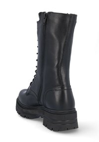 Botín de combate de cuero negro con diseño hasta la mitad de la pantorrilla, cierre delantero con cordones, cremallera, suela robusta y acabado texturizado.