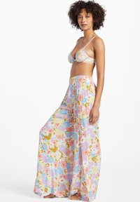 Virágmintás bikini szett és bő szárú nadrág, pasztell színekben, lágy textúrával, különböző virágok élénk mintájával díszítve.