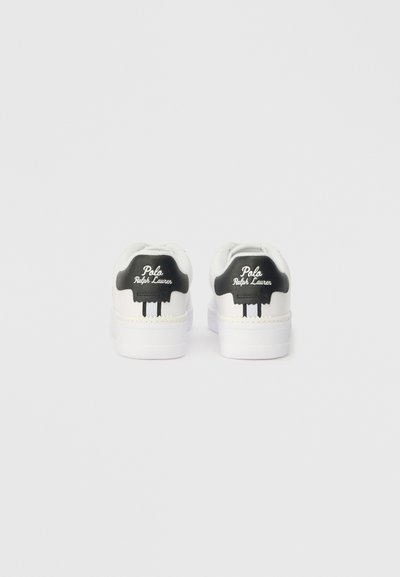 Ténis brancos com detalhes na parte de trás em preto e a marca "Polo Ralph Lauren". Apresentam uma textura suave, forma arredondada e um design minimalista.