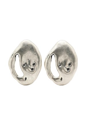 Orecchini astratti di tono argento con una forma ondulata e organica. Presentano un design a intaglio e una superficie liscia e lucida con una leggera lucentezza.