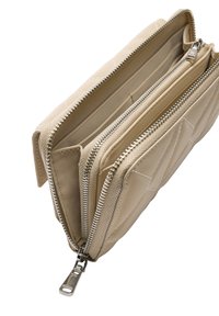 Beżowy pikowany portfel z wieloma przegródkami. Wyposażony w srebrne zamki błyskawiczne i detale przeszycia. Gładka tekstura o prostokątnym kształcie.