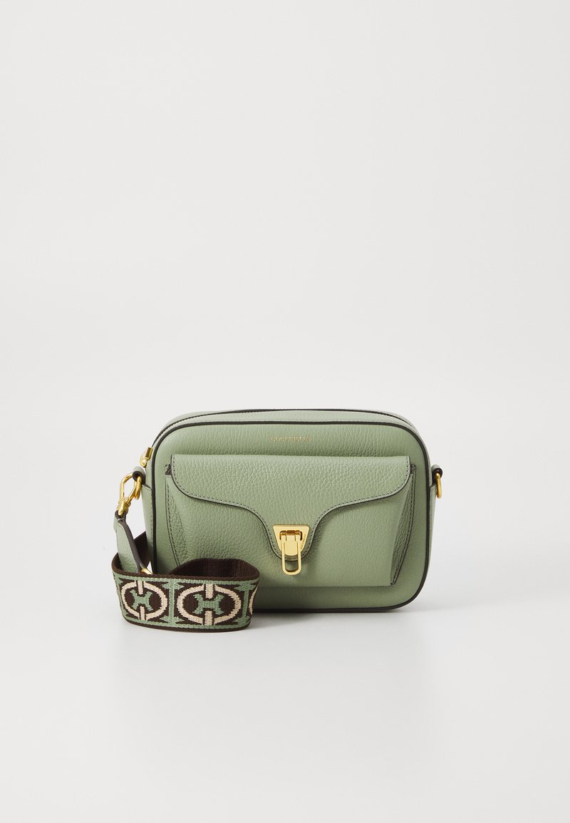 Green leather crossbody bag with gold hardware, featuring a front pocket and a patterned strap. Zipper closure with contrast stitching.