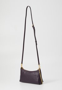 Leather handbag in dark purple with a smooth texture, featuring a zipper closure and gold-tone chain and strap accents.