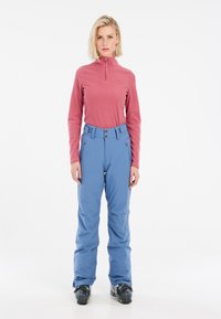 Lightweight, pink fleece zip-up top paired with blue snow pants; pants feature two pockets and a button closure; soft texture, practical design.