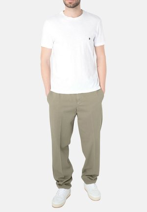 T-shirt in cotone bianco con scollo rotondo, abbinato a pantaloni leggeri di colore oliva e sneaker bianche, con una vestibilità rilassata e dettagli minimi.