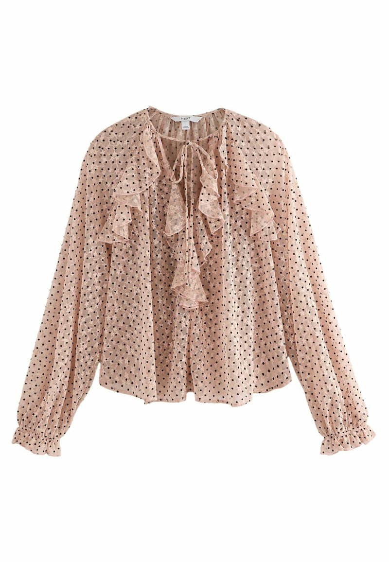 Blouse rose clair avec des pois noirs, encolure froncée, manches longues avec des poignets froncés, et une fermeture à nouer à l'avant.