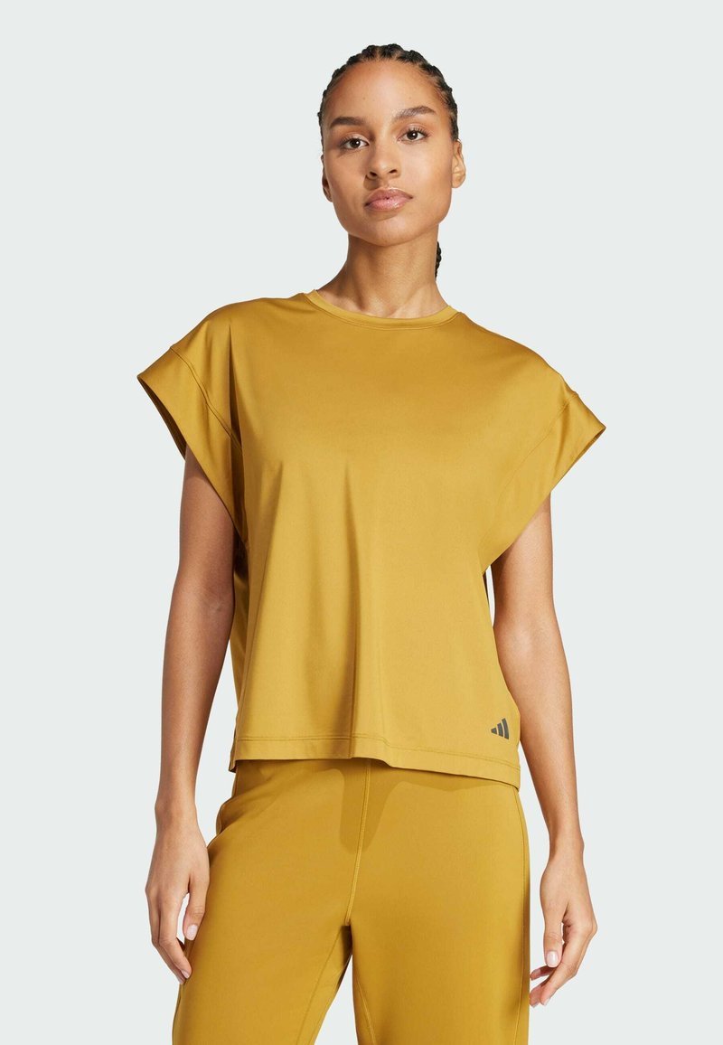 Camiseta deportiva de manga corta en color amarillo mostaza, fabricada en una tela suave y con un corte relajado. Presenta un cuello redondo y un sutil logo en un costado.
