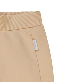 Beige katoenen sweatpants met een geribbelde tailleband en een klein geweven label aan de zijkant. Glad texture en getailleerde pasvorm.