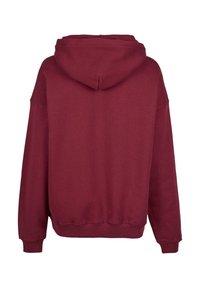 Bordeaux hettegenser med stor baklomme, myk stoffkvalitet og ribbede mansjetter. Har hette og en komfortabel, oversized passform.