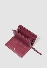 Cartera de piel burdeos con un compartimento con cremallera, múltiples ranuras para tarjetas y un cierre a presión. Textura suave con bordes limpios y definidos.