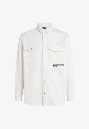 Camisa blanca de botones de mezcla de algodón. Presenta dos bolsillos en el pecho, botones a presión plateados y el logo "KARL LAGERFELD JEANS" en negro.