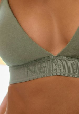 Zeleni pamukasti bralette s V-izrezom i teksturiranim pojasom na kojem piše "NEXT." Glatka tekstura i bešavne ivice povećavaju udobnost.
