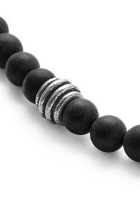 Black beaded bracelet featuring matte black spheres and a textured silver spacer with grooves, contrasting in color and finish.